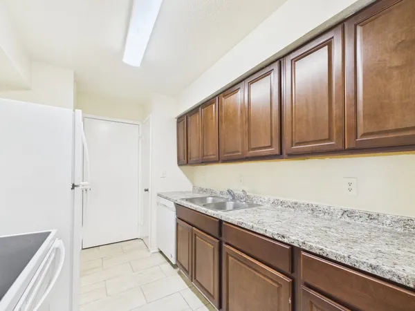 a kitchen with granite countertop cabinets stainless steel appliances and a counter space