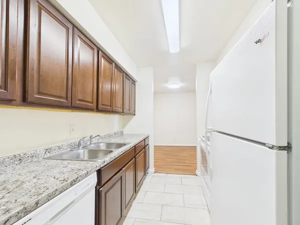 a kitchen with granite countertop stainless steel appliances a refrigerator and a sink