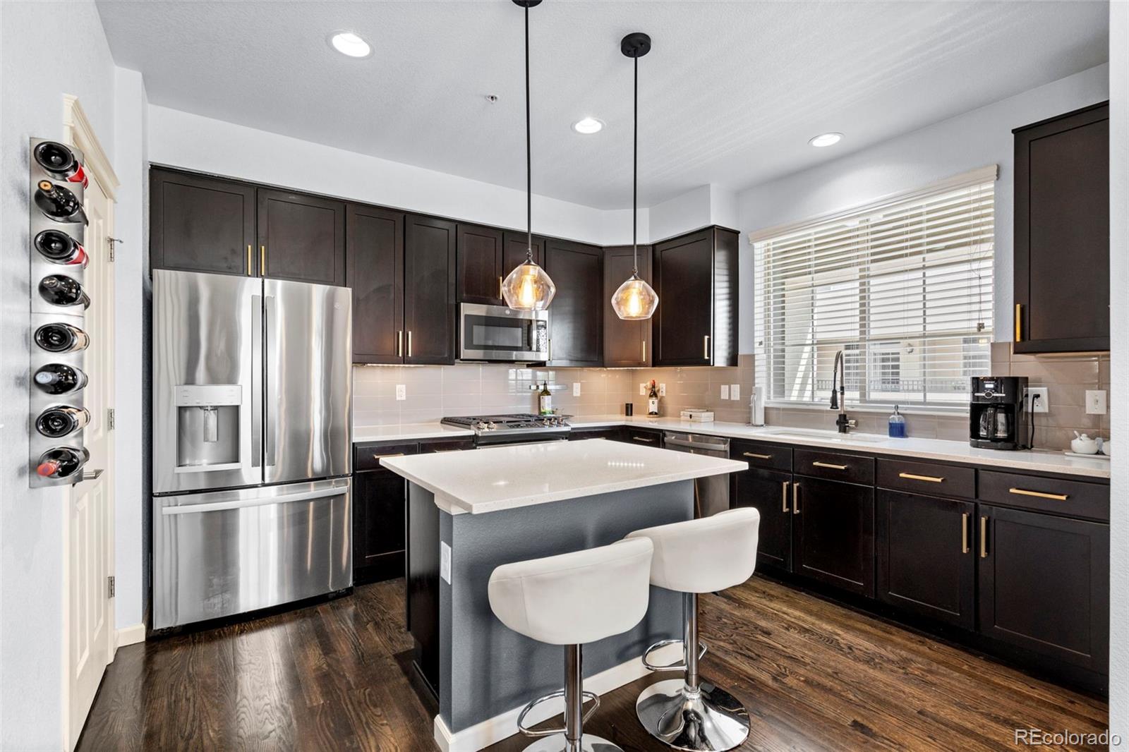 1124 Rockhurst Drive, Unit A Highlands Ranch, CO 80129 - Photo 11 of 45 a kitchen with stainless steel appliances granite countertop a sink a stove a refrigerator and island with wooden floor