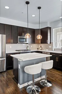 a kitchen with kitchen island stainless steel appliances a sink cabinets and wooden floor