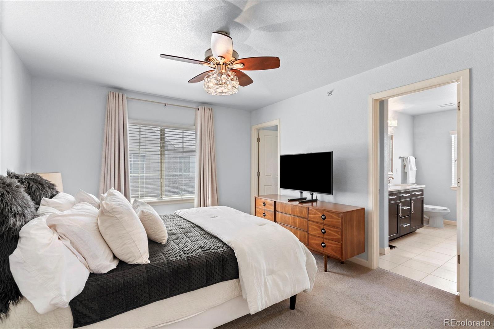 1124 Rockhurst Drive, Unit A Highlands Ranch, CO 80129 - Photo 25 of 45 a bedroom with a bed and a flat screen tv