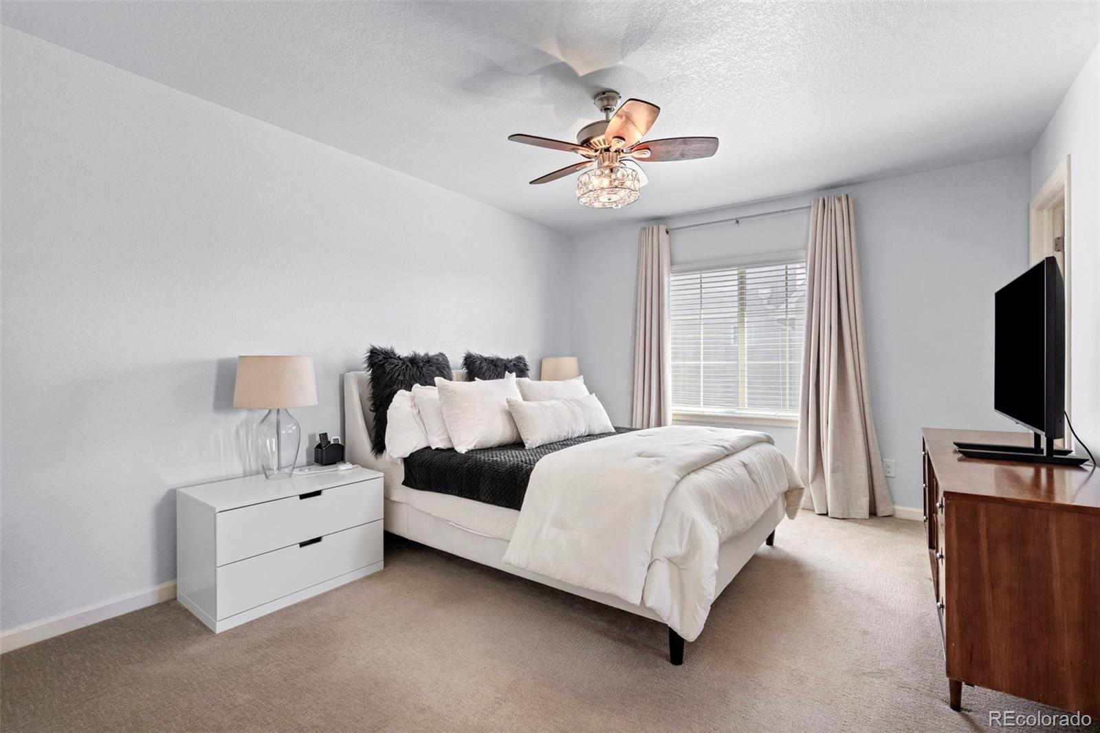 1124 Rockhurst Drive, Unit A Highlands Ranch, CO 80129 - Photo 26 of 45 a bedroom with bed and flat tv