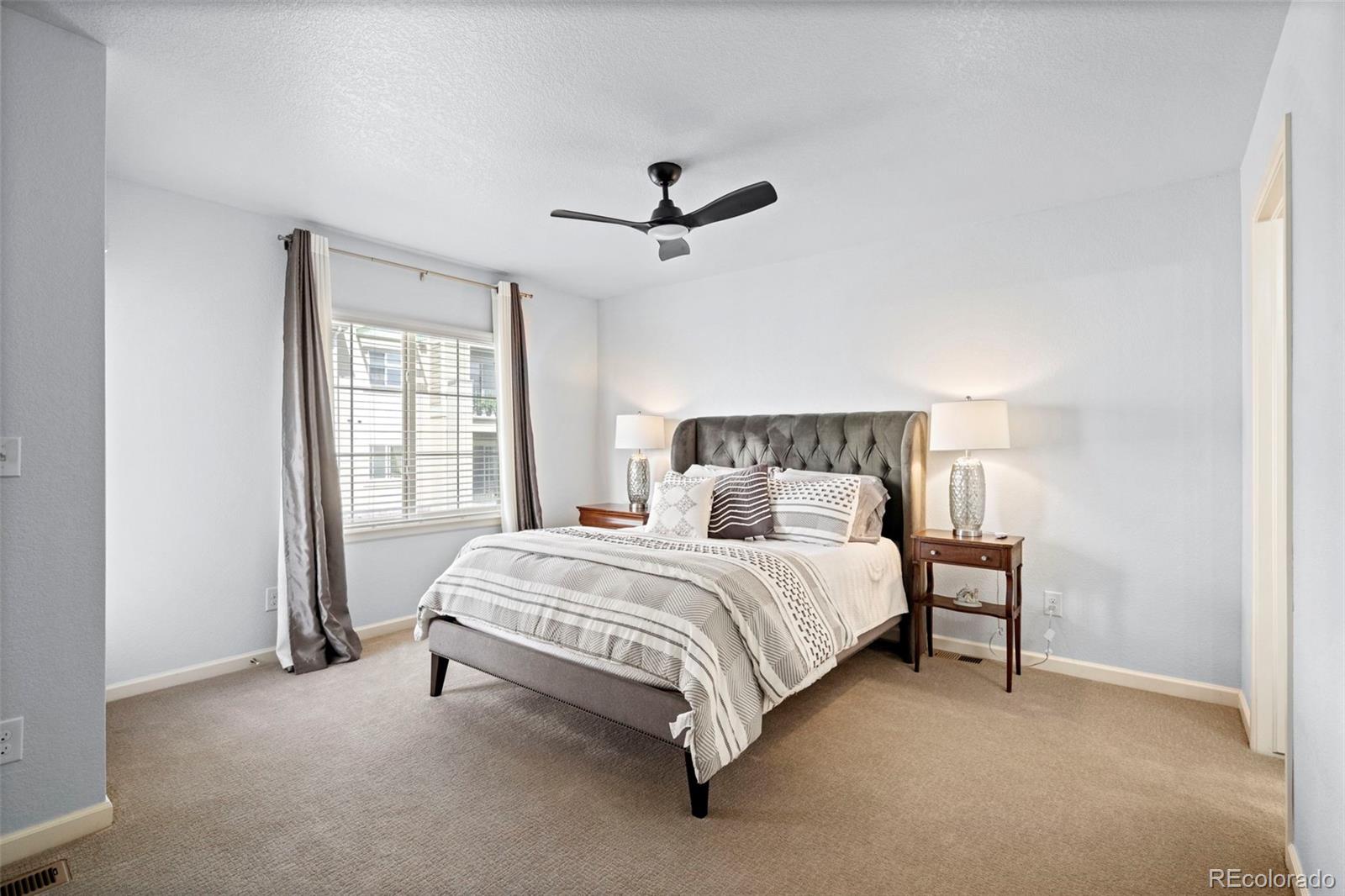 1124 Rockhurst Drive, Unit A Highlands Ranch, CO 80129 - Photo 31 of 45 a bedroom with a bed lamp and window