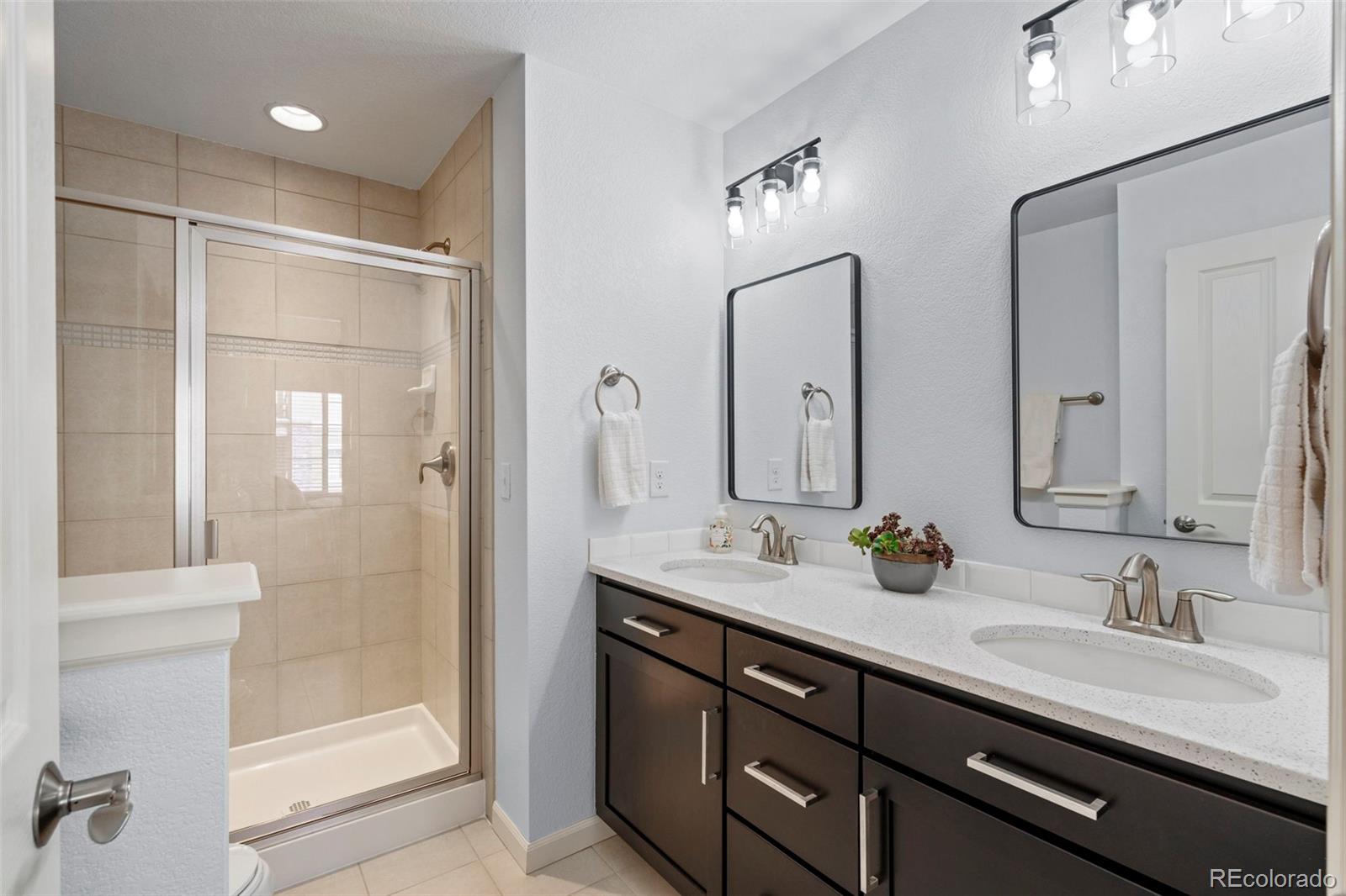 1124 Rockhurst Drive, Unit A Highlands Ranch, CO 80129 - Photo 32 of 45 a bathroom with a double vanity sink mirror double and shower