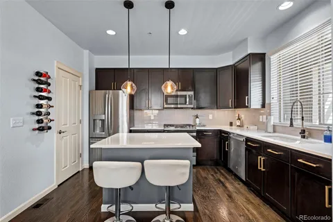 a kitchen with a dining table chairs cabinets and stainless steel appliances