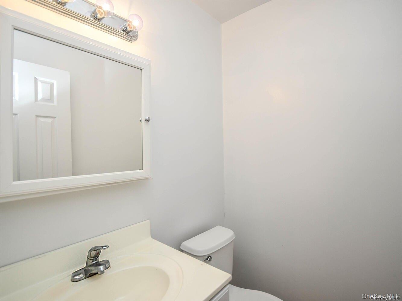 34 Firwood Road, Unit B Port Washington, NY 11050 - Photo 7 of 25 a bathroom with a sink a toilet and a mirror