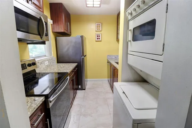 a kitchen with stainless steel appliances granite countertop a stove and a microwave