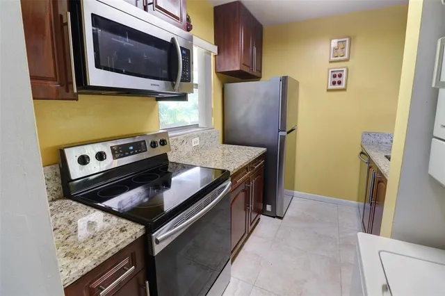 a kitchen with stainless steel appliances granite countertop a stove microwave and refrigerator