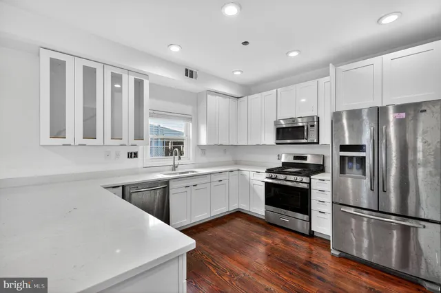 a kitchen with appliances a sink and cabinets
