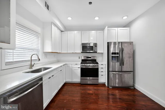 a kitchen with a sink stainless steel appliances and window