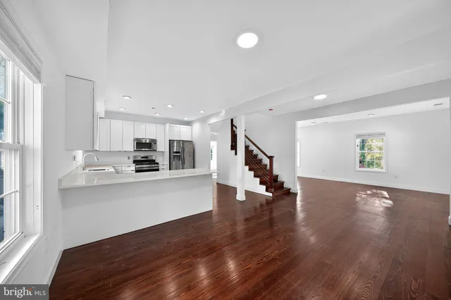 a view of kitchen with stainless steel appliances refrigerator stove microwave and cabinets