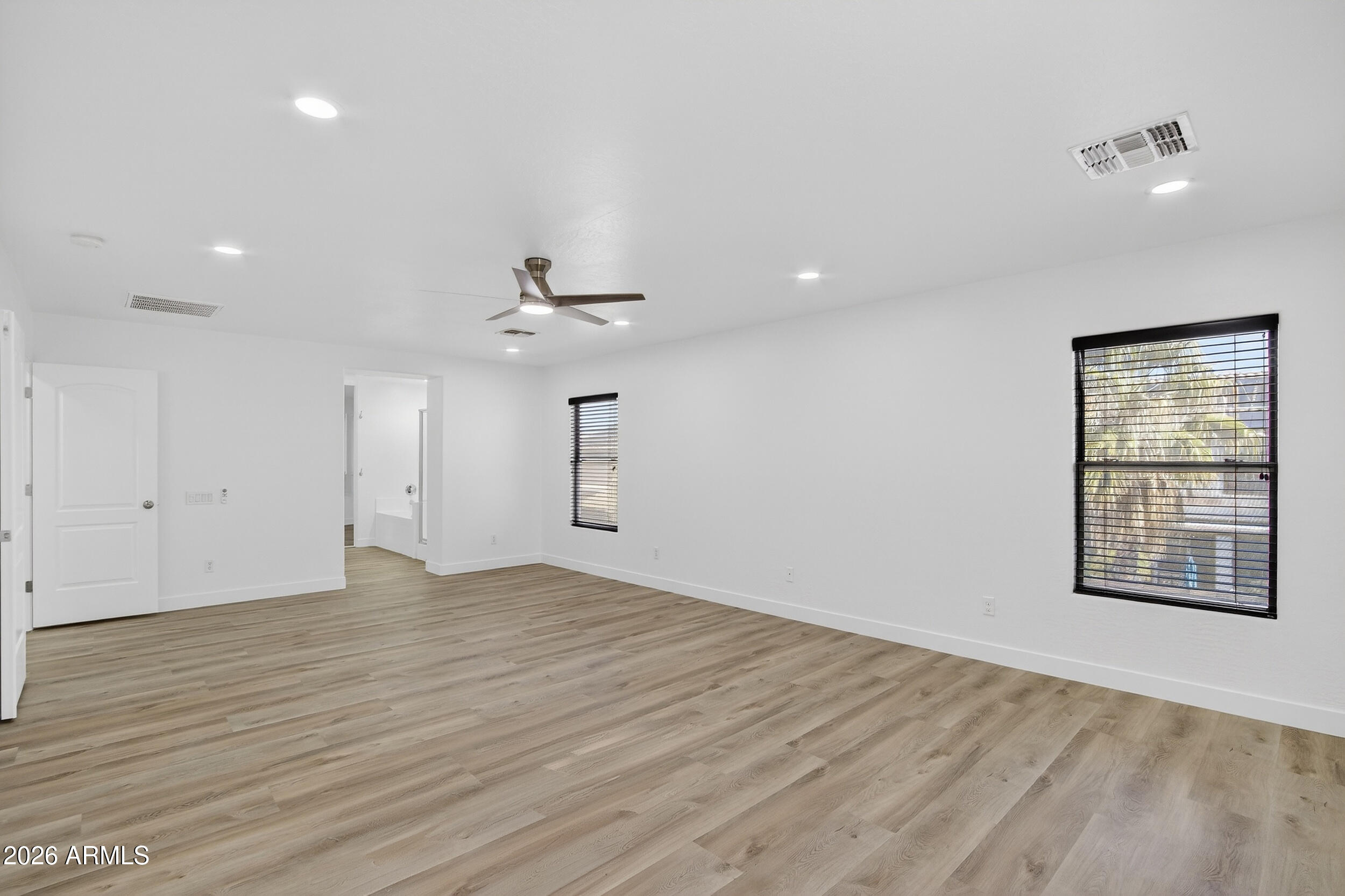 43620 West Cowpath Road Maricopa, AZ 85138 - Photo 32 of 60 an empty room with wooden floor cabinet and windows