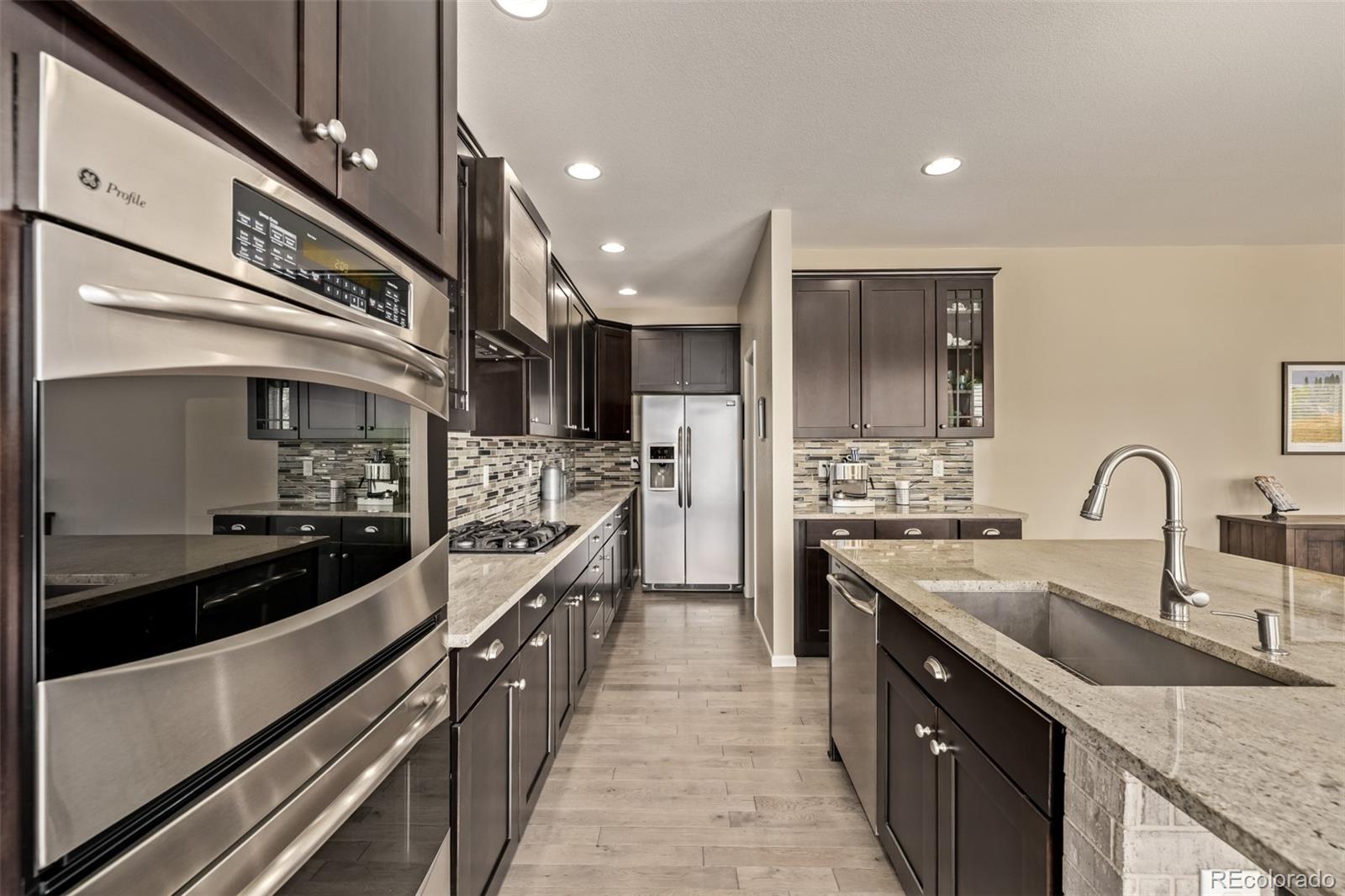 2289 Moss Place Erie, CO 80516 - Photo 11 of 45 a large kitchen with stainless steel appliances and a sink