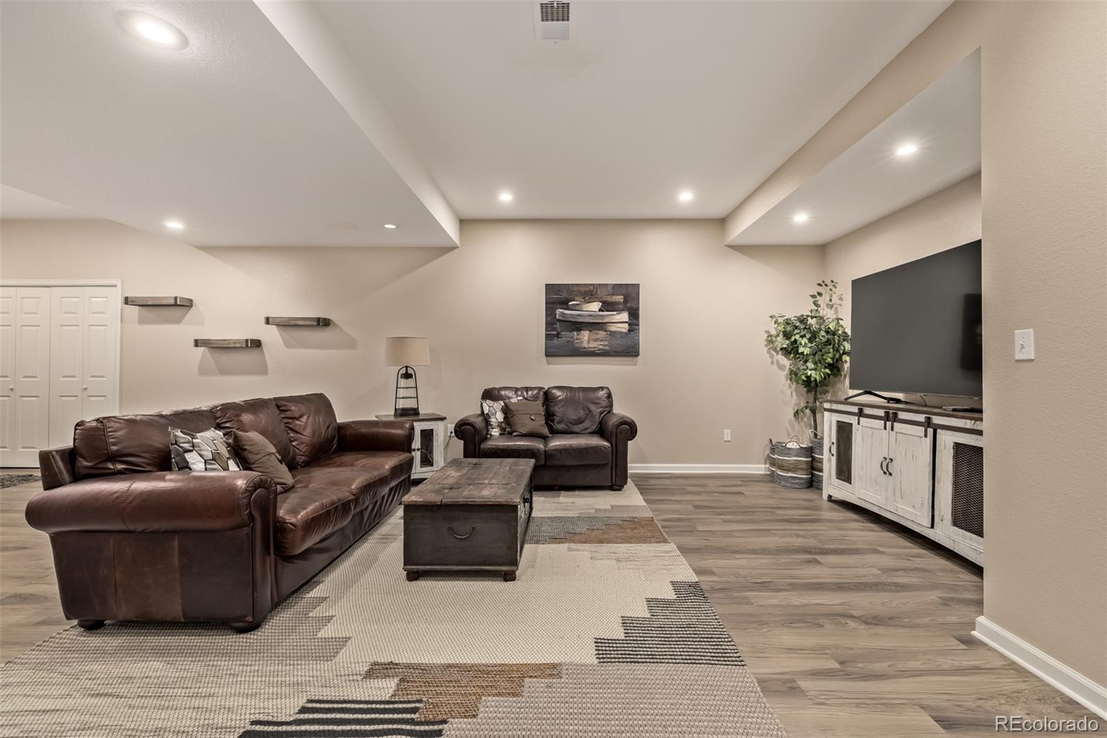 2289 Moss Place Erie, CO 80516 - Photo 31 of 45 a living room with furniture and a flat screen tv