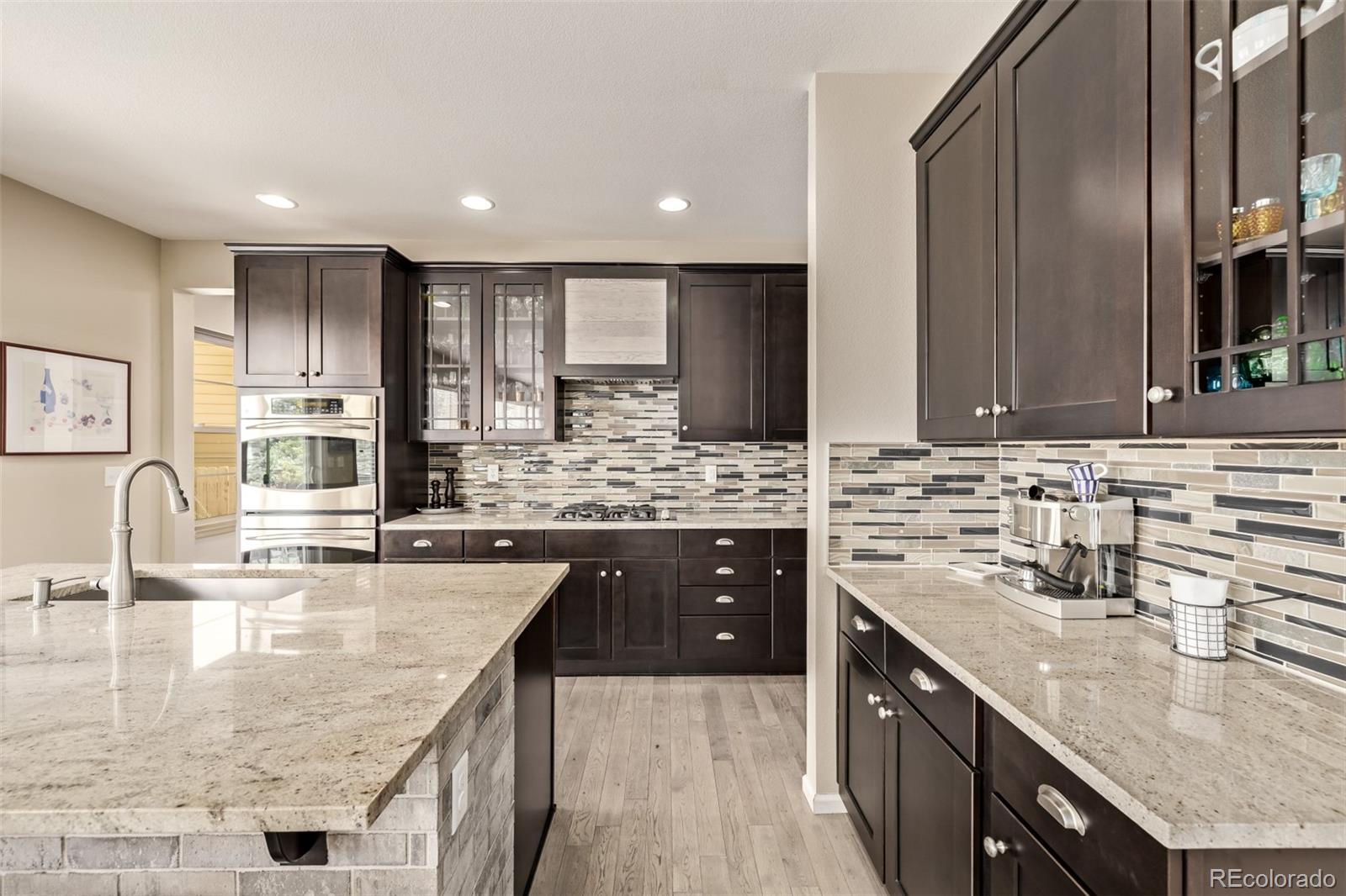 2289 Moss Place Erie, CO 80516 - Photo 10 of 45 a kitchen with stainless steel appliances granite countertop a sink a stove and cabinets