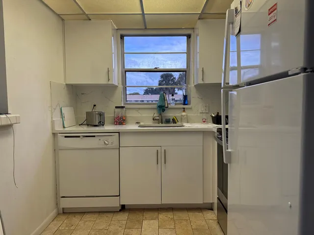 a kitchen with a sink cabinets and window