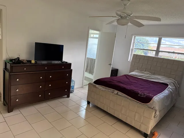 a bedroom with a bed and a flat tv screen on dresser