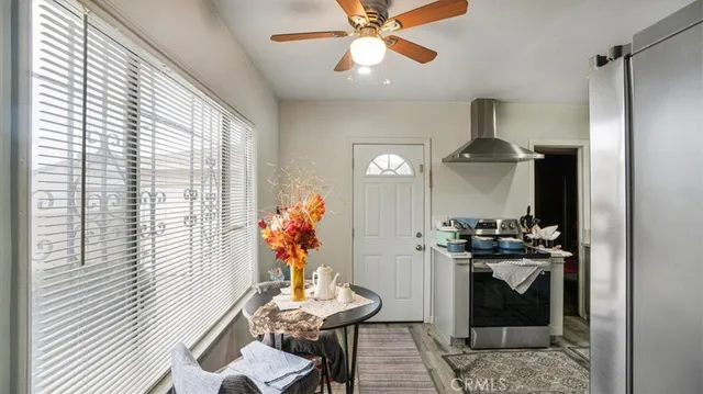 a kitchen with stainless steel appliances a stove a chimney a sink and cabinets