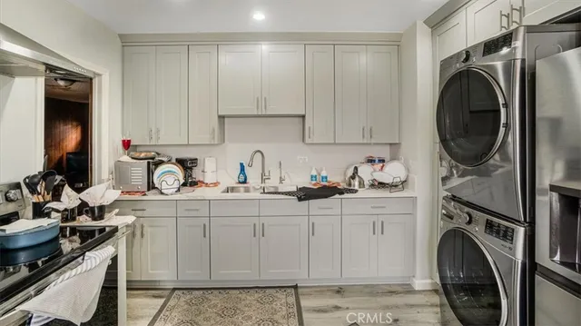 a kitchen with stainless steel appliances sink a washer and dryer