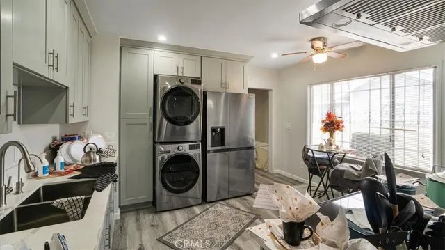 a view of a kitchen with sink washing machine and windows