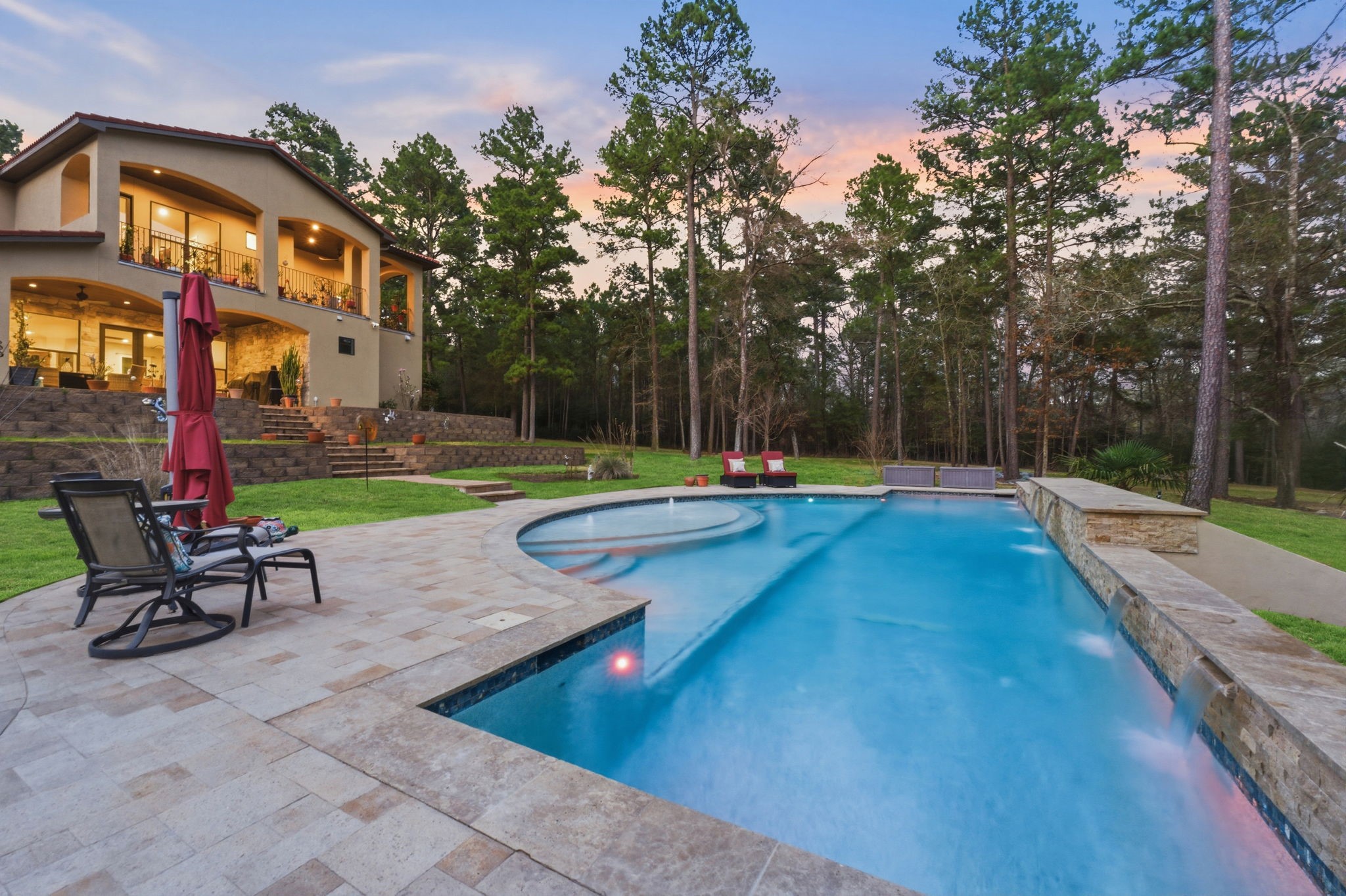 280 Sundog Road Huntsville, TX 77340 - Photo 45 of 50 Beautiful evening view of the pool creates a perfect setting for relaxing outdoors and enjoying peaceful evenings surrounded by trees.