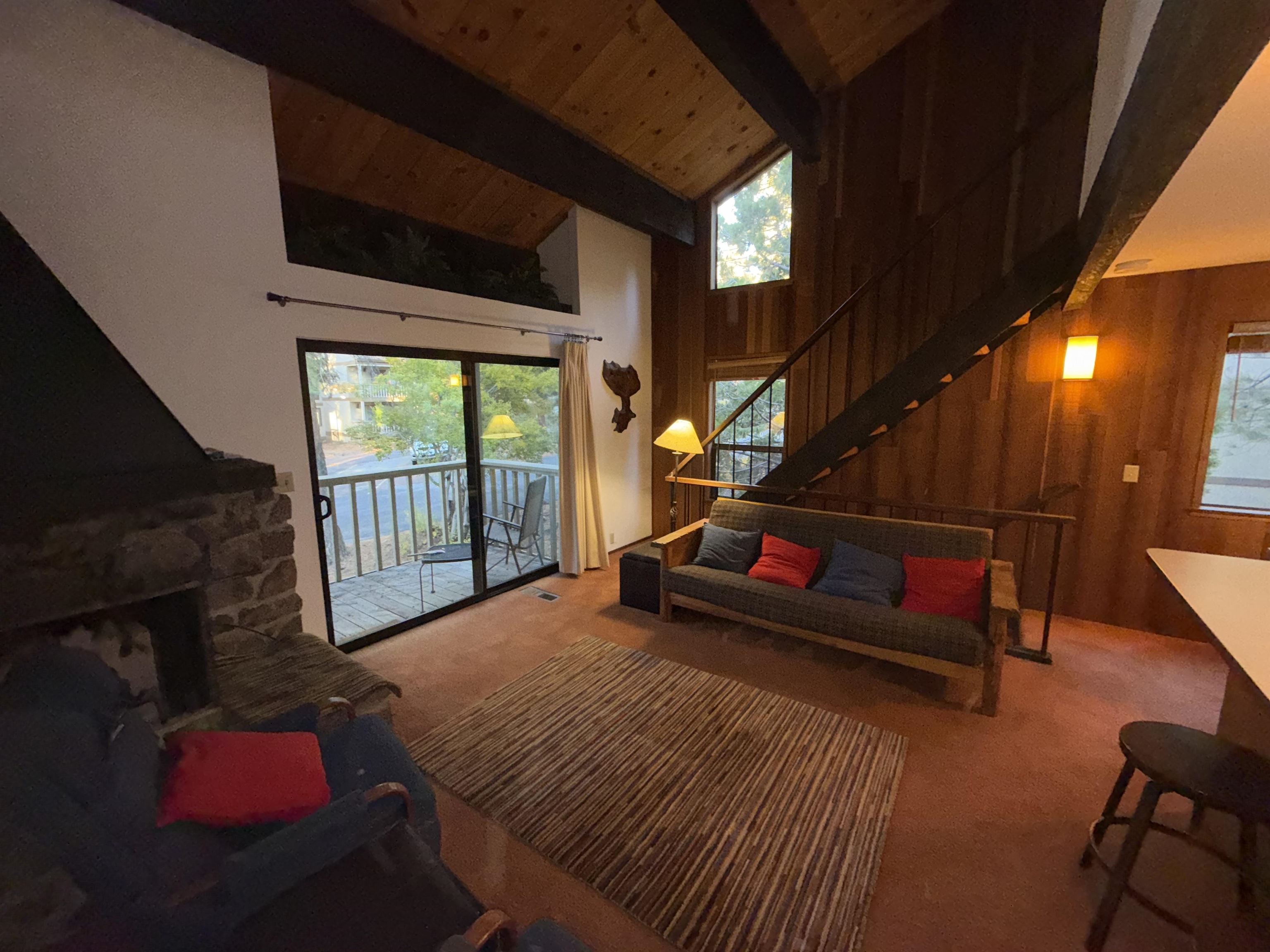 1001 Commonwealth Drive, Unit 97 Kings Beach, CA 96143 - Photo 3 of 28 a living room with furniture a flat screen tv and a floor to ceiling window