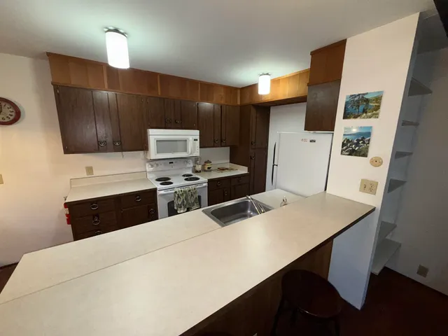 a kitchen with stainless steel appliances a stove a sink island and a refrigerator