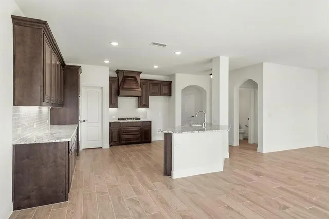 a large kitchen with stainless steel appliances a large counter top a stove and a refrigerator