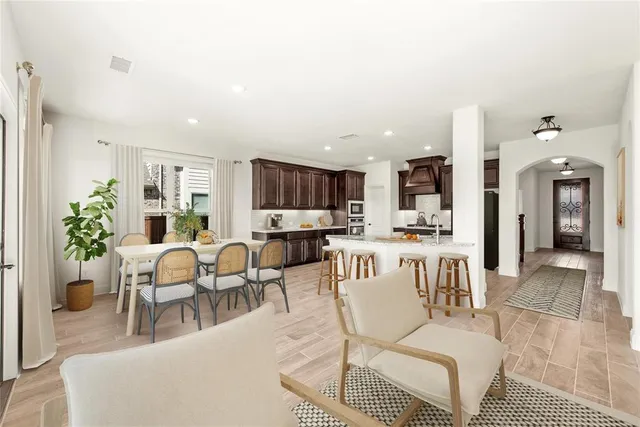 a living room with furniture kitchen view and a potted plant