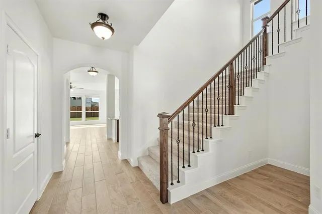 a view of a hallway with wooden floor and staircase