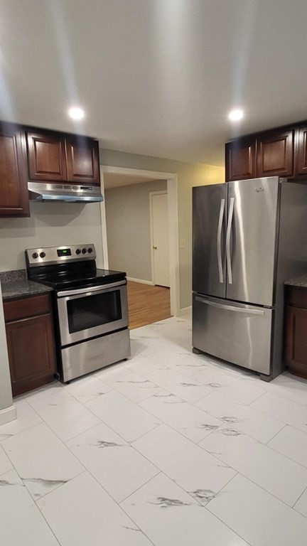 a view of kitchen with stainless steel appliances granite countertop a stove a refrigerator and a microwave