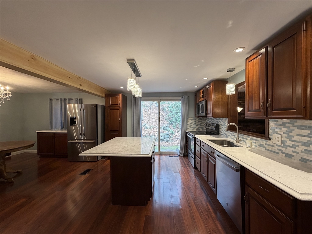 264 Flynt Street Palmer, MA 01069 - Photo 5 of 21 a large kitchen with stainless steel appliances kitchen island granite countertop a large stove a sink dishwasher and cabinets with wooden floor