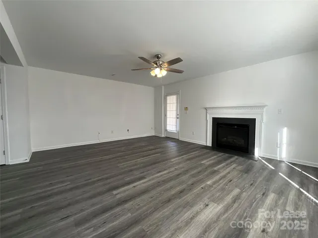 a view of an empty room with a fireplace and a window
