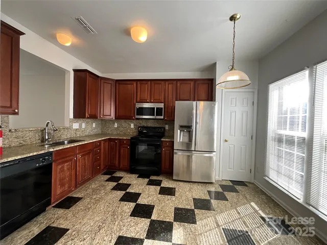 a kitchen with stainless steel appliances granite countertop a refrigerator and a sink