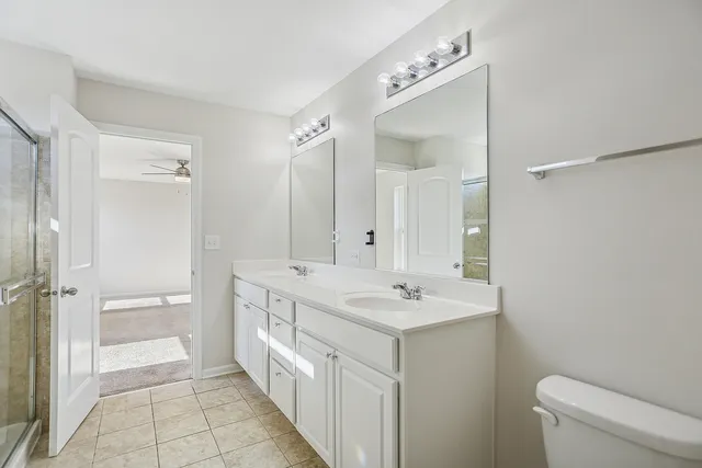 a bathroom with a double vanity sink mirror and toilet