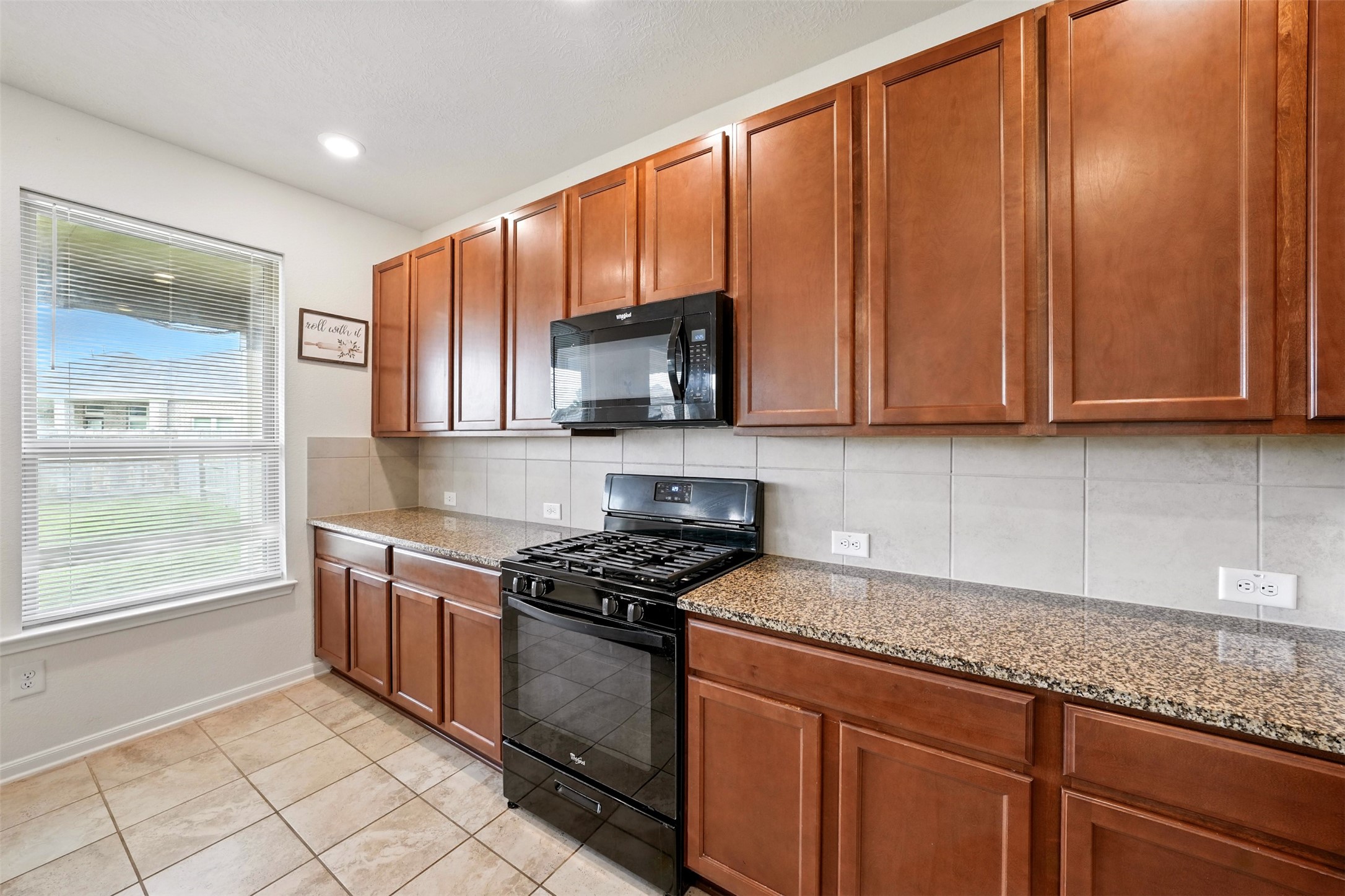 15410 Rosehill Summit Lane Houston, TX 77044 - Photo 12 of 30 a kitchen with stainless steel appliances granite countertop a stove a sink and a microwave