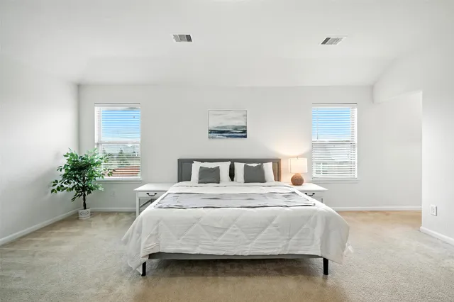 a bedroom with a large bed and potted plant