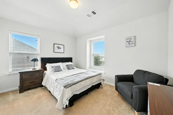 a bedroom with bed couch and window