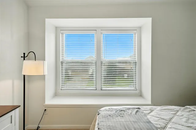a view of a bedroom with a bed and a window