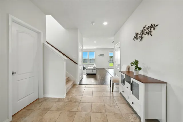 a hallway with a white cabinets and potted plant
