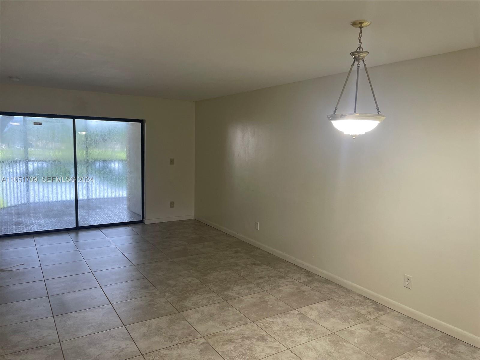 3252 Foxcroft Road, Unit 206 Miramar, FL 33025 - Photo 4 of 10 an empty room with a ceiling fan and a window