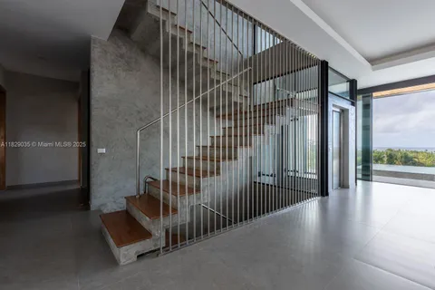 a view of staircase with railing and a rug