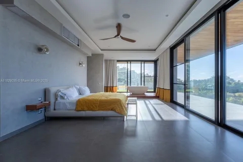 a spacious bedroom with a bed and large glass window