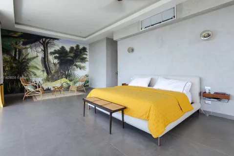 a bed sitting in a bedroom next to a window