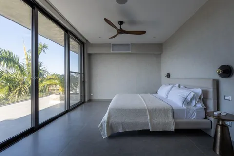 a bedroom with a bed and a large window