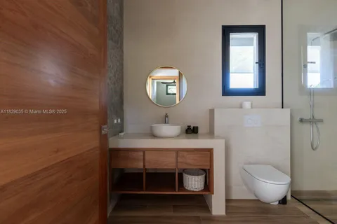 a bathroom with a toilet a sink and mirror