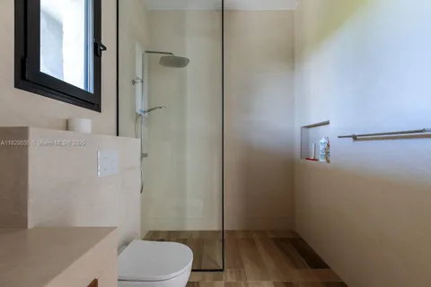 a bathroom with a toilet and a shower