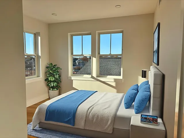 a bedroom with a bed and large windows
