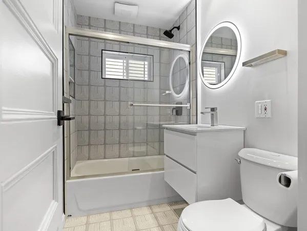 a bathroom with a toilet a sink and mirror