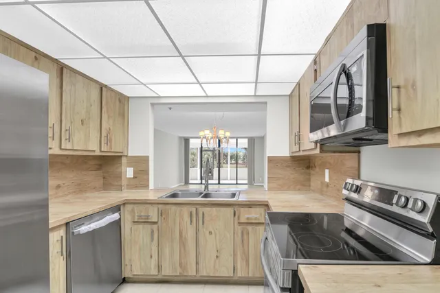 a kitchen with stainless steel appliances granite countertop a sink a stove and cabinets